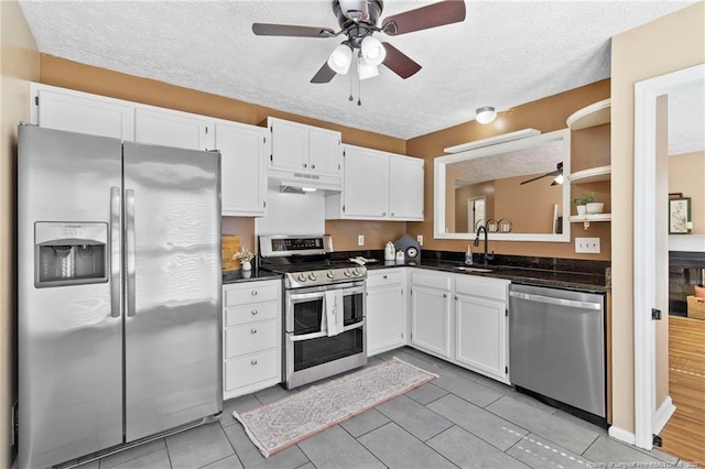3820 Crusader Dr, Hope Mills, NC 28348 - kitchen featuring stainless steel appliances, a ceiling fan, under cabinet range hood, dark countertops, and a textured ceiling