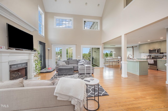 656 Atkins Rd, Fuquay Varina, NC 27526 - living room featuring high vaulted ceiling, light wood-type flooring, and a high end fireplace