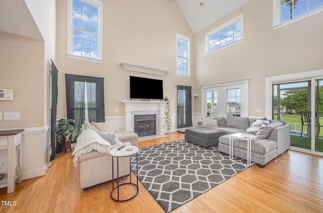 656 Atkins Rd, Fuquay Varina, NC 27526 - living area with high vaulted ceiling, wood finished floors, a fireplace with flush hearth, and healthy amount of natural light