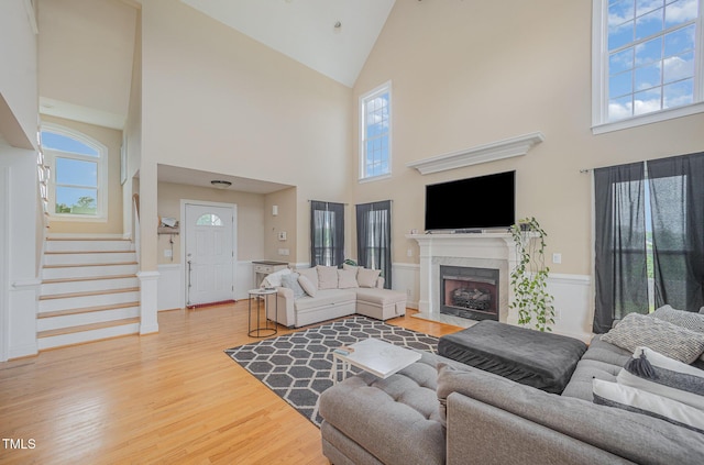 656 Atkins Rd, Fuquay Varina, NC 27526 - living area featuring high vaulted ceiling, a fireplace, light wood finished floors, and stairway