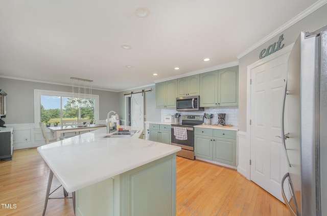 656 Atkins Rd, Fuquay Varina, NC 27526 - kitchen featuring stainless steel appliances, green cabinetry, a barn door, crown molding, and light countertops