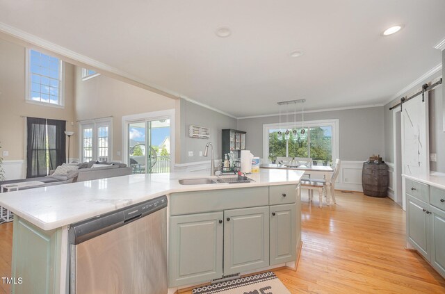 656 Atkins Rd, Fuquay Varina, NC 27526 - kitchen with stainless steel dishwasher, a barn door, light countertops, crown molding, and an island with sink