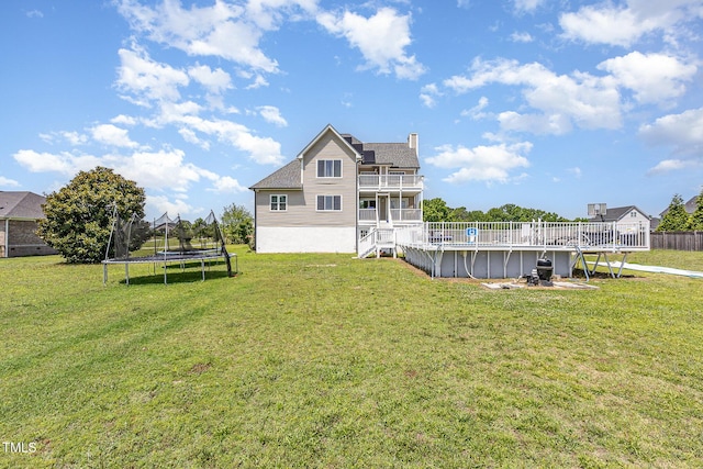 656 Atkins Rd, Fuquay Varina, NC 27526 - rear view of property with a trampoline, an outdoor pool, a chimney, a balcony, and a lawn