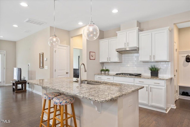 1416 Southpoint Trl, Durham, NC 27713 - kitchen with dark wood-type flooring, tasteful backsplash, a center island with sink, white cabinets, and recessed lighting