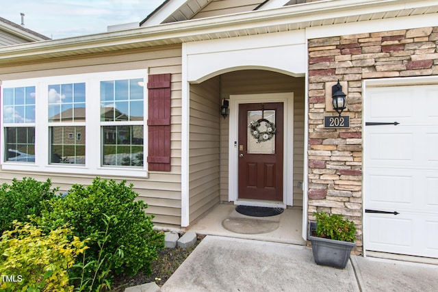 202 E Painted Way, Clayton, NC 27527 - doorway to property with stone siding and a garage