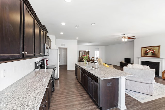 202 E Painted Way, Clayton, NC 27527 - kitchen with appliances with stainless steel finishes, dark wood finished floors, ceiling fan, an island with sink, and recessed lighting