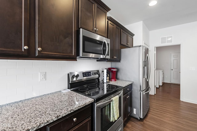 202 E Painted Way, Clayton, NC 27527 - kitchen with stainless steel appliances, washer and clothes dryer, dark wood-type flooring, dark brown cabinets, and decorative backsplash