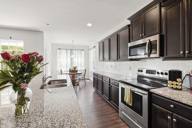 202 E Painted Way, Clayton, NC 27527 - kitchen featuring stainless steel appliances, backsplash, light stone counters, dark wood-type flooring, and recessed lighting