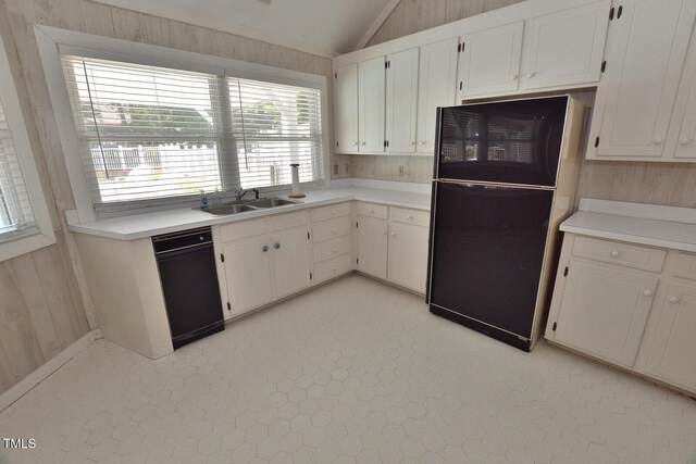 2708 Coleberry Trl, Rocky Mount, NC 27804 - kitchen with freestanding refrigerator, vaulted ceiling, light countertops, white cabinetry, and wood walls