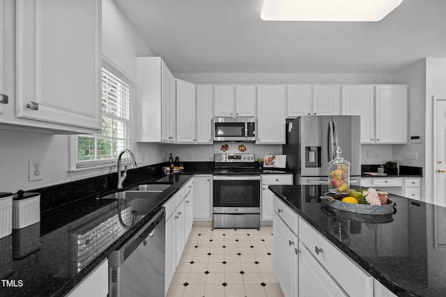 8 Summertime Ct, Durham, NC 27707 - kitchen with stainless steel appliances, white cabinetry, light floors, and dark stone counters