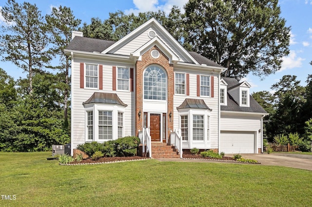 8 Summertime Ct, Durham, NC 27707 - colonial house with concrete driveway, a chimney, a front lawn, an attached garage, and roof with shingles