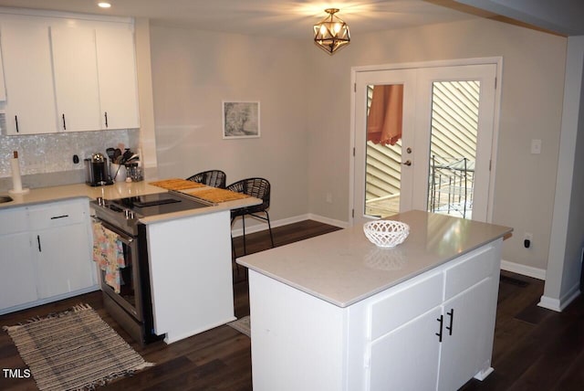 80 Stoneridge Rd, Durham, NC 27705 - kitchen featuring stainless steel electric stove, dark wood-type flooring, light countertops, white cabinetry, and backsplash
