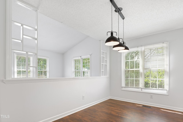 613 Penncross Dr, Raleigh, NC 27610 - empty room featuring a textured ceiling, dark wood-type flooring, lofted ceiling, and a chandelier