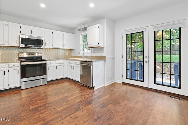 613 Penncross Dr, Raleigh, NC 27610 - kitchen featuring stainless steel appliances, dark wood finished floors, healthy amount of natural light, backsplash, and recessed lighting