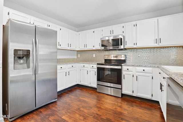 613 Penncross Dr, Raleigh, NC 27610 - kitchen with appliances with stainless steel finishes, white cabinets, light stone counters, and backsplash