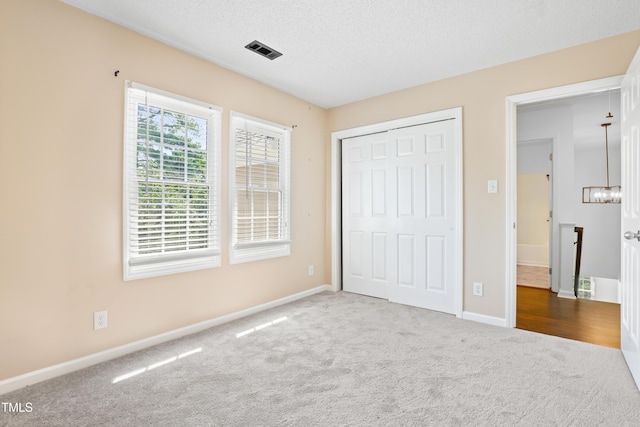 613 Penncross Dr, Raleigh, NC 27610 - unfurnished bedroom featuring carpet floors, a closet, and a textured ceiling