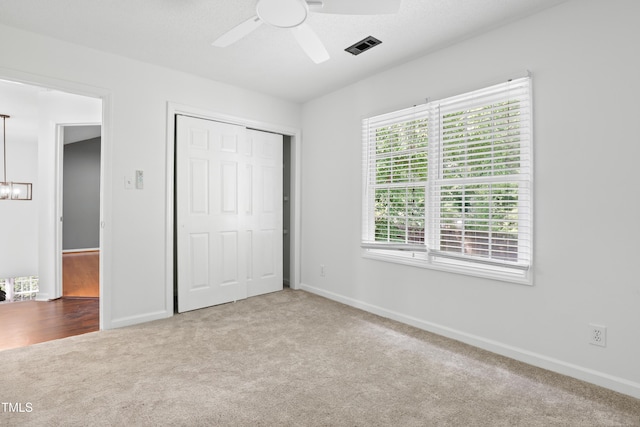 613 Penncross Dr, Raleigh, NC 27610 - unfurnished bedroom featuring carpet, a closet, a chandelier, and ceiling fan
