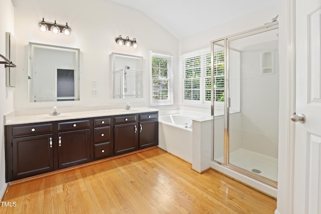 613 Penncross Dr, Raleigh, NC 27610 - full bath featuring lofted ceiling, wood finished floors, a shower stall, double vanity, and a bath