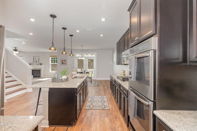 1127 Timbercut Dr, Durham, NC 27703 - kitchen with stainless steel appliances, light wood-type flooring, a kitchen bar, recessed lighting, and decorative light fixtures