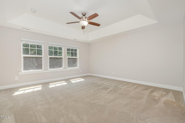 1127 Timbercut Dr, Durham, NC 27703 - spare room featuring a raised ceiling, ceiling fan, light carpet, and a smoke detector