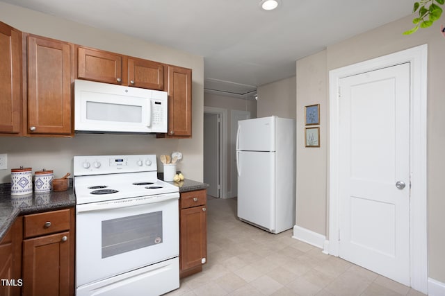 2423 Farthing St, Durham, NC 27704 - kitchen with white appliances, brown cabinets, and dark countertops