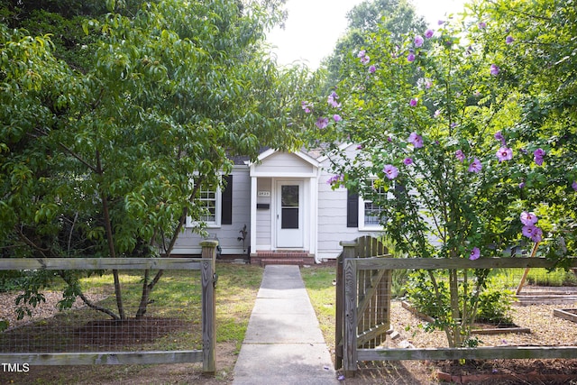 2423 Farthing St, Durham, NC 27704 - view of property hidden behind natural elements with a fenced front yard and a gate