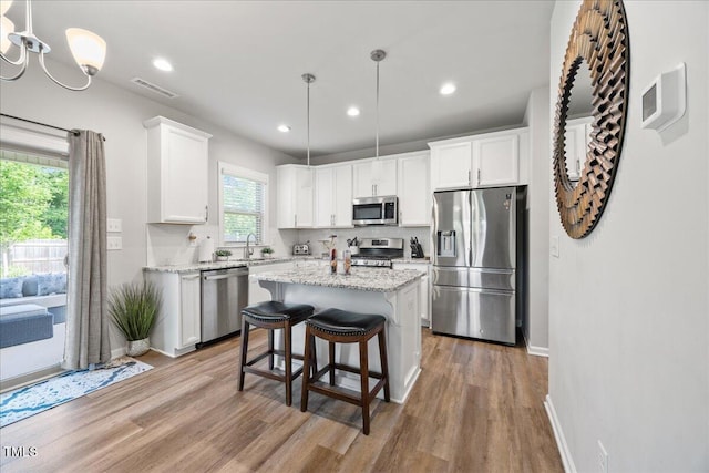 601 Richlands Cliff Dr, Youngsville, NC 27596 - kitchen featuring appliances with stainless steel finishes, light wood-style flooring, white cabinets, a center island, and recessed lighting