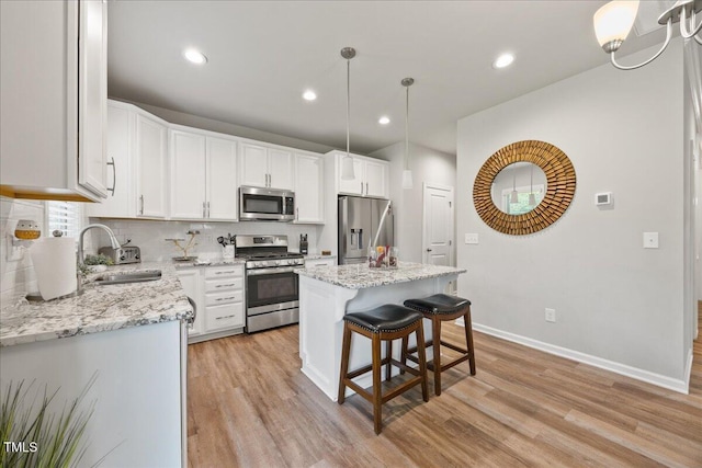 601 Richlands Cliff Dr, Youngsville, NC 27596 - kitchen featuring appliances with stainless steel finishes, light wood-style floors, a center island, white cabinets, and recessed lighting