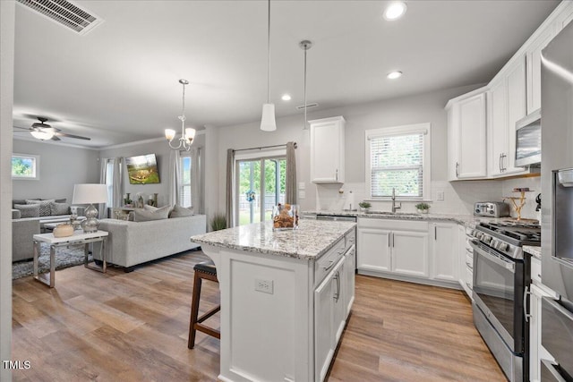 601 Richlands Cliff Dr, Youngsville, NC 27596 - kitchen featuring appliances with stainless steel finishes, open floor plan, recessed lighting, white cabinetry, and tasteful backsplash