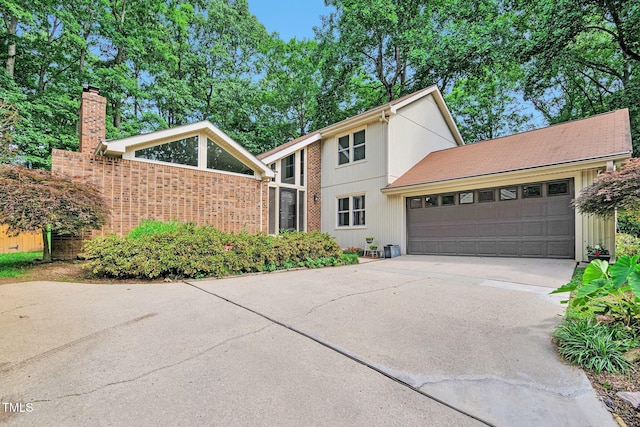 6701 Winding Trl, Raleigh, NC 27612 - mid-century home featuring driveway, an attached garage, and a chimney
