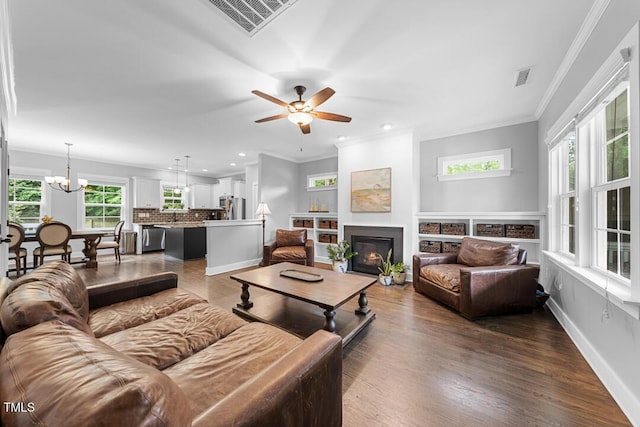 1920 Hart St, Durham, NC 27703 - living area featuring plenty of natural light, a glass covered fireplace, dark wood-style flooring, a chandelier, and recessed lighting