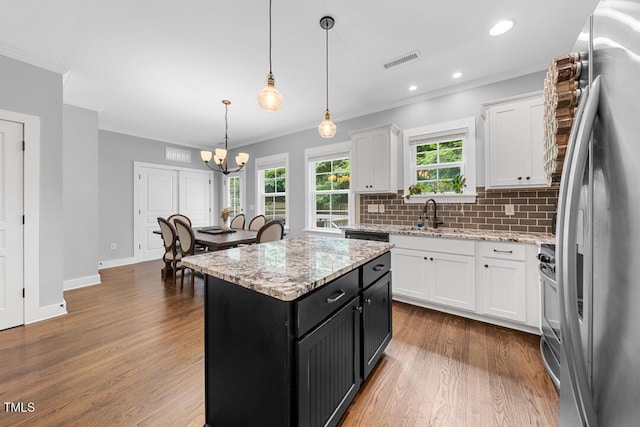 1920 Hart St, Durham, NC 27703 - kitchen with appliances with stainless steel finishes, ornamental molding, white cabinets, a chandelier, and dark cabinets