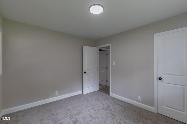 1708 Forest Rd, Durham, NC 27705 - unfurnished bedroom with carpet flooring and baseboards