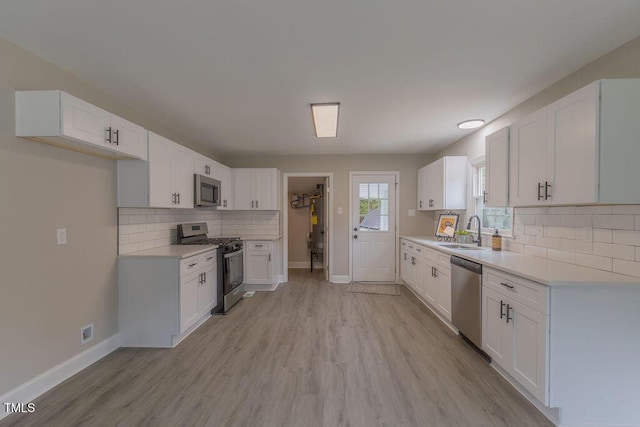 1708 Forest Rd, Durham, NC 27705 - kitchen with stainless steel appliances, decorative backsplash, and white cabinetry
