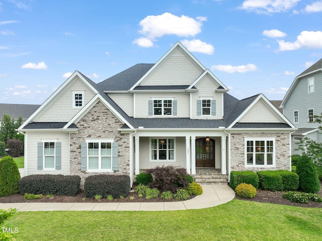 121 Hardy Oaks Way, Holly Springs, NC 27540 - craftsman house with a front lawn, a porch, stone siding, and a shingled roof