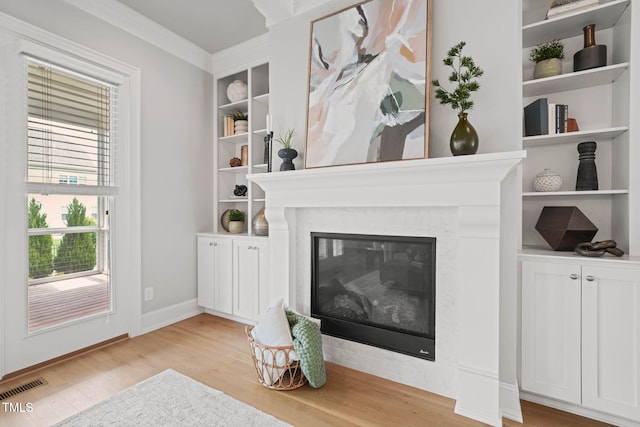 121 Hardy Oaks Way, Holly Springs, NC 27540 - living area with light wood finished floors, crown molding, a fireplace, and built in features