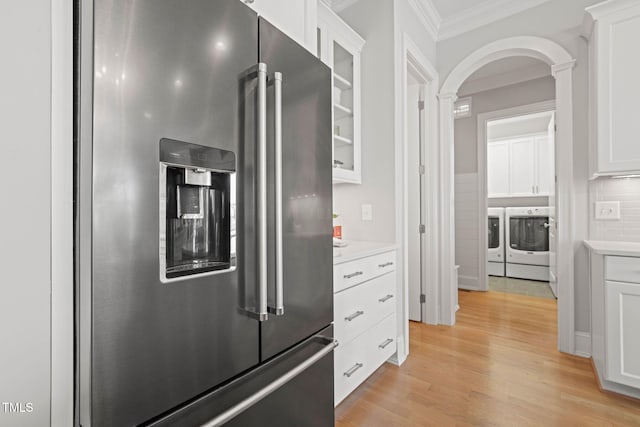 121 Hardy Oaks Way, Holly Springs, NC 27540 - kitchen with high end refrigerator, washing machine and clothes dryer, crown molding, arched walkways, and light wood-style floors