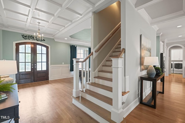 121 Hardy Oaks Way, Holly Springs, NC 27540 - foyer featuring french doors, arched walkways, coffered ceiling, a chandelier, and light wood-style floors