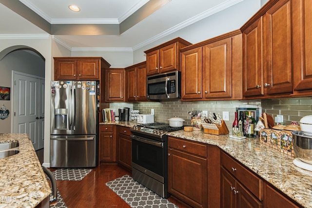 514 Ashley Woods Dr, Gibsonville, NC 27249 - kitchen featuring stainless steel appliances, arched walkways, dark wood-style flooring, decorative backsplash, and crown molding