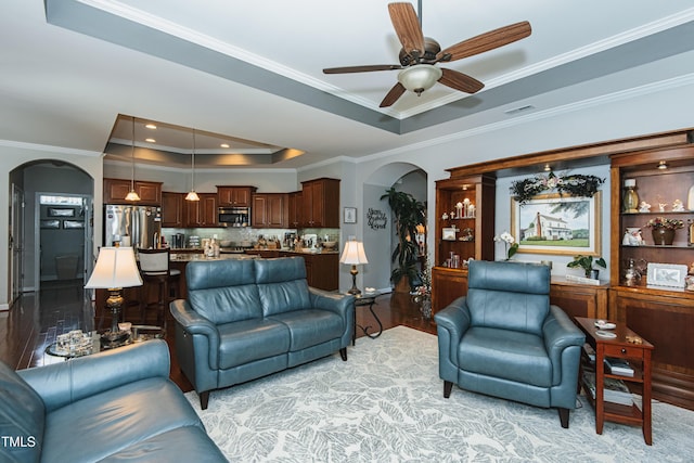514 Ashley Woods Dr, Gibsonville, NC 27249 - living room with arched walkways, a tray ceiling, crown molding, ceiling fan, and light wood-type flooring