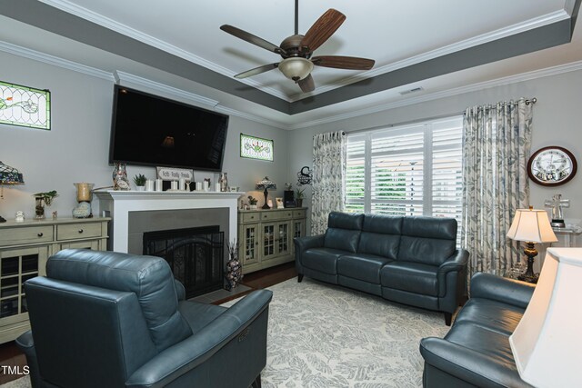 514 Ashley Woods Dr, Gibsonville, NC 27249 - living room featuring ceiling fan, a fireplace with flush hearth, crown molding, wood finished floors, and a tray ceiling