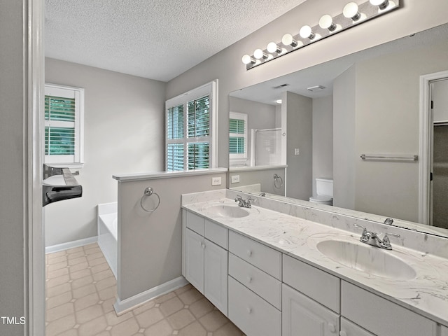8640 Swarthmore Dr, Raleigh, NC 27615 - full bathroom with double vanity, a bath, a textured ceiling, and a shower