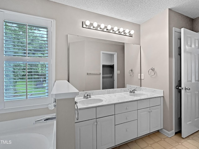 8640 Swarthmore Dr, Raleigh, NC 27615 - full bathroom with double vanity, a textured ceiling, a garden tub, and tile patterned flooring