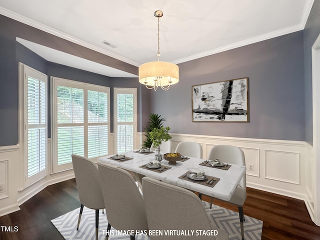 8640 Swarthmore Dr, Raleigh, NC 27615 - dining space featuring a chandelier, dark wood-style flooring, wainscoting, crown molding, and a decorative wall