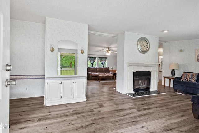558 Christys Way, Roxboro, NC 27574 - living room with wood finished floors, a textured ceiling, a fireplace, ceiling fan, and wallpapered walls
