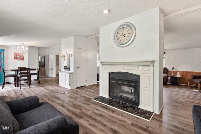 558 Christys Way, Roxboro, NC 27574 - living area with wood finished floors, a chandelier, a textured ceiling, and a glass covered fireplace