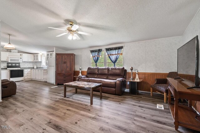 558 Christys Way, Roxboro, NC 27574 - living area featuring a textured ceiling, a wainscoted wall, ceiling fan, wood finished floors, and wood walls