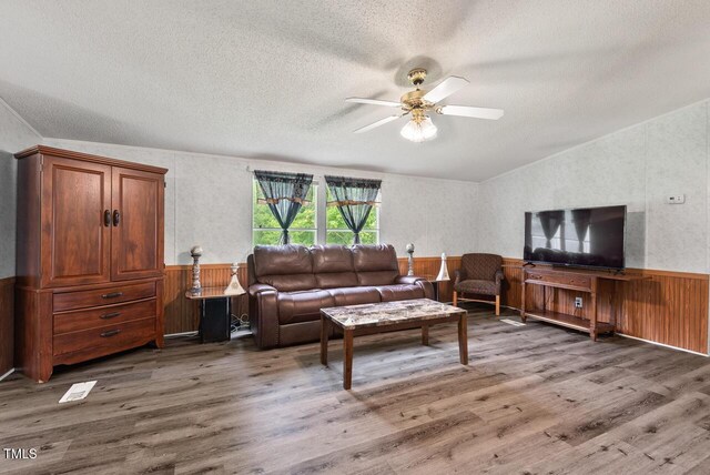 558 Christys Way, Roxboro, NC 27574 - living room with a textured ceiling, ceiling fan, a wainscoted wall, wood finished floors, and lofted ceiling