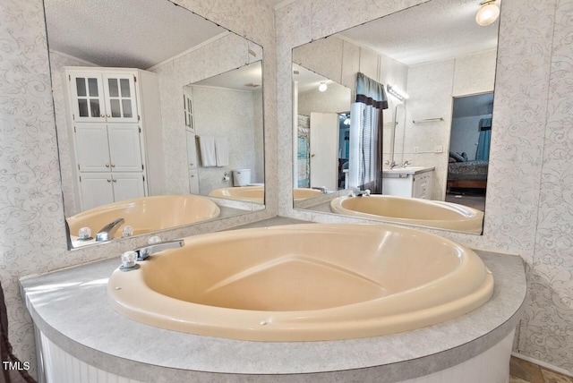 558 Christys Way, Roxboro, NC 27574 - full bathroom featuring wallpapered walls, a textured ceiling, connected bathroom, and double vanity