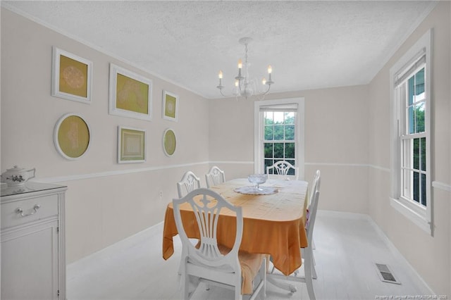 92 Nathan Dudley Rd, Clinton, NC 28328 - dining space featuring a chandelier, a textured ceiling, and ornamental molding